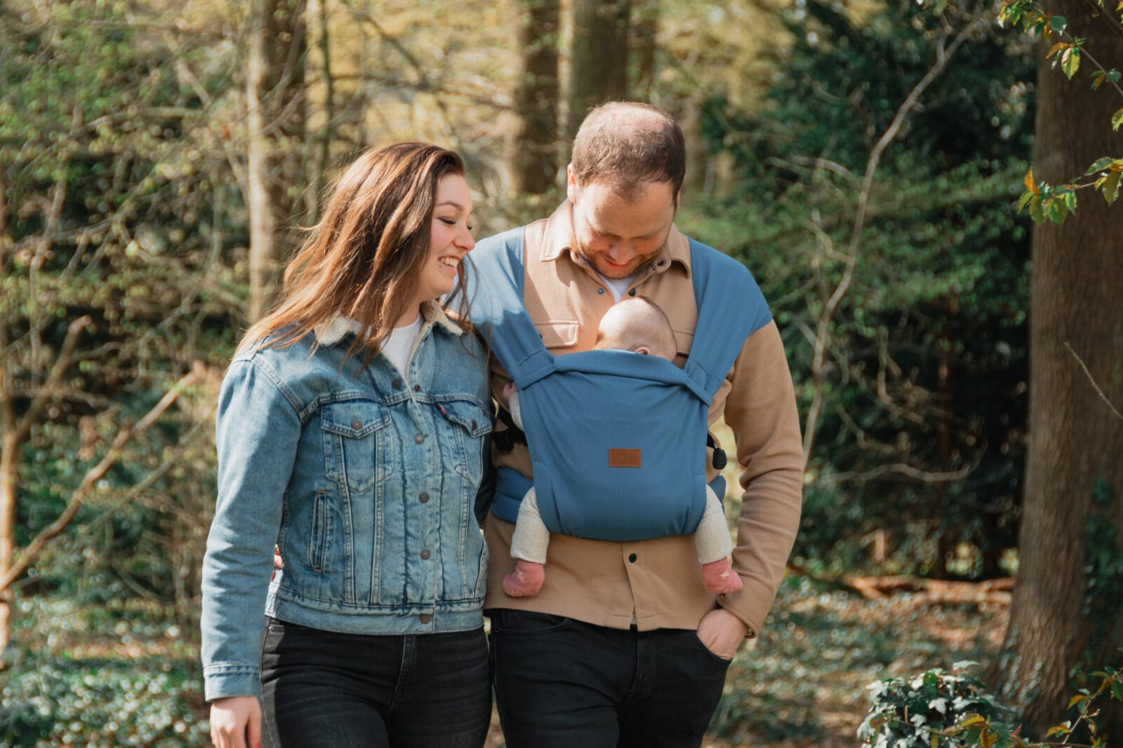 Gezin met vader die kind draagt in ByKay draagzak